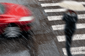 Pedestrian crossing a street in rain